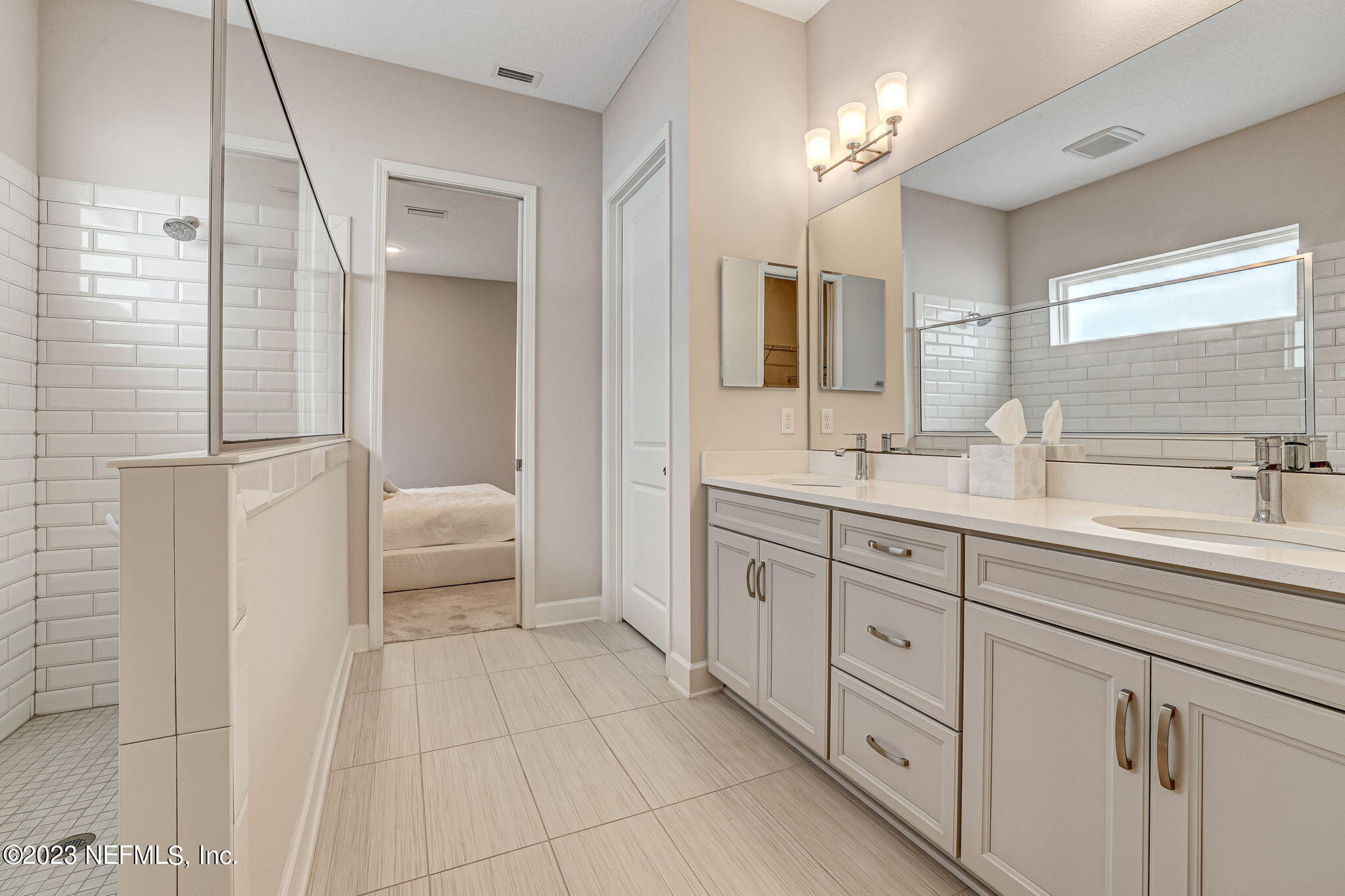 9863 Invention Lane Jacksonville, FL 32256 - Photo 26 of 56 a spacious bathroom with a double vanity sink a mirror and a shower