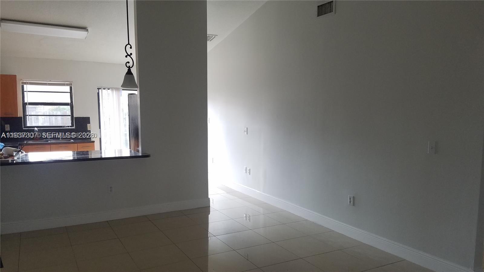 13516 Southwest 59th Lane Miami, FL 33183 - Photo 16 of 20 a view of an empty room with wooden floor and a window