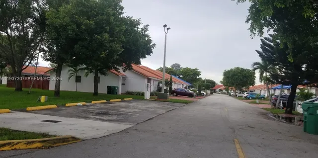 a row of palm trees in front of a house