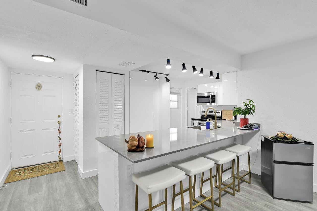 a kitchen with stainless steel appliances a table and chairs in it