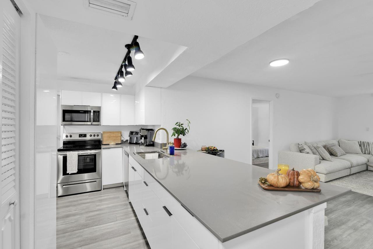 250 Northwest 67th Street, Unit 322 Boca Raton, FL 33487 - Photo 3 of 15 a kitchen with granite countertop a sink and appliances