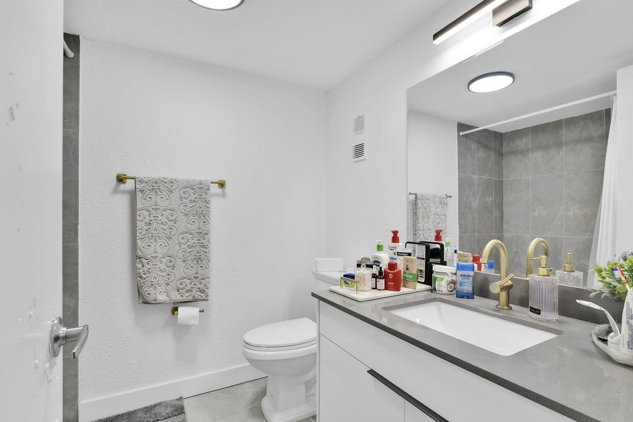 250 Northwest 67th Street, Unit 322 Boca Raton, FL 33487 - Photo 5 of 15 a bathroom with a sink vanity mirror and toilet