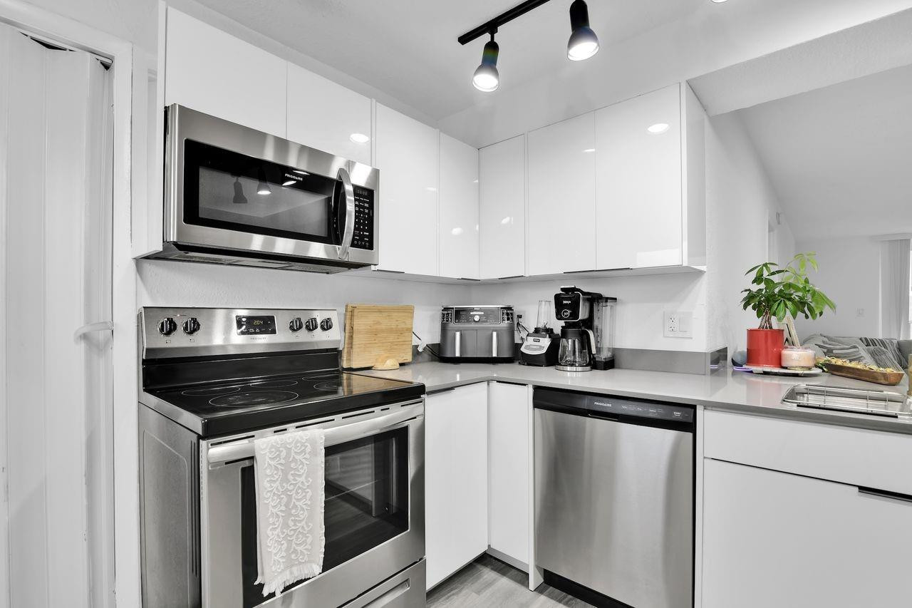250 Northwest 67th Street, Unit 322 Boca Raton, FL 33487 - Photo 7 of 15 a kitchen with a stove and a microwave