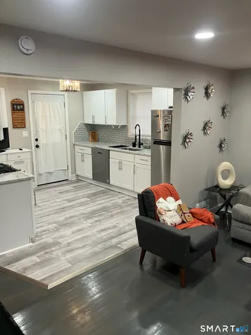 a living room with furniture and kitchen