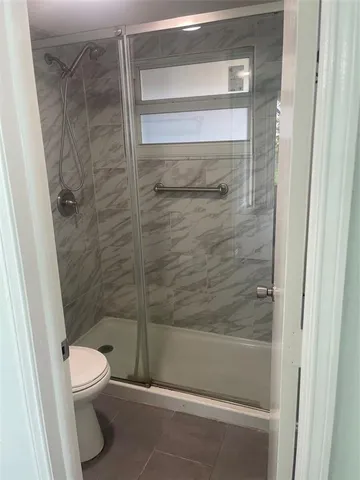 a bathroom with a toilet and a shower