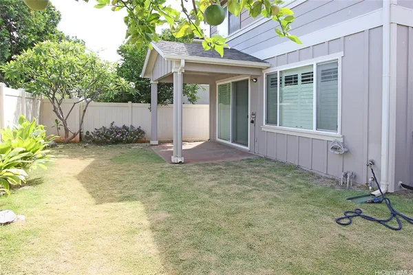 a view of a house with a yard and potted plants
