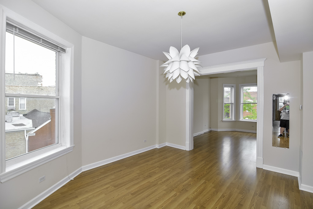 2145 West Chicago Avenue, Unit 2 Chicago, IL 60622 - Photo 4 of 19 a view of an empty room with wooden floor and a window