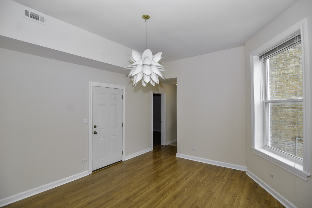 2145 West Chicago Avenue, Unit 2 Chicago, IL 60622 - Photo 5 of 19 a view of an empty room with a window and wooden floor