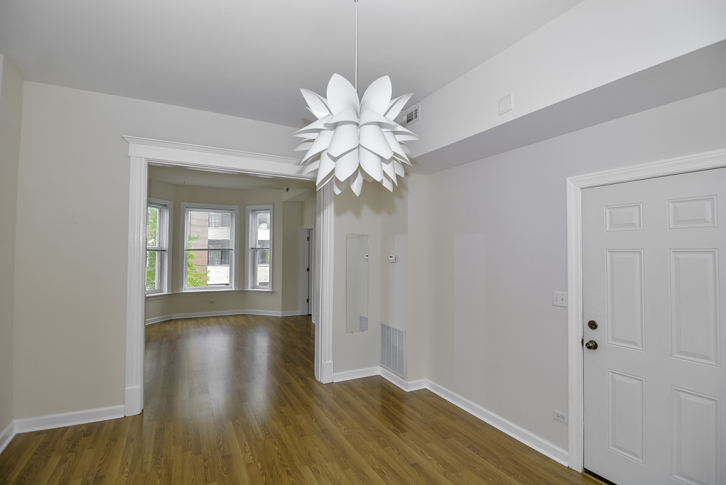 2145 West Chicago Avenue, Unit 2 Chicago, IL 60622 - Photo 6 of 19 a view of an empty room with wooden floor and a window