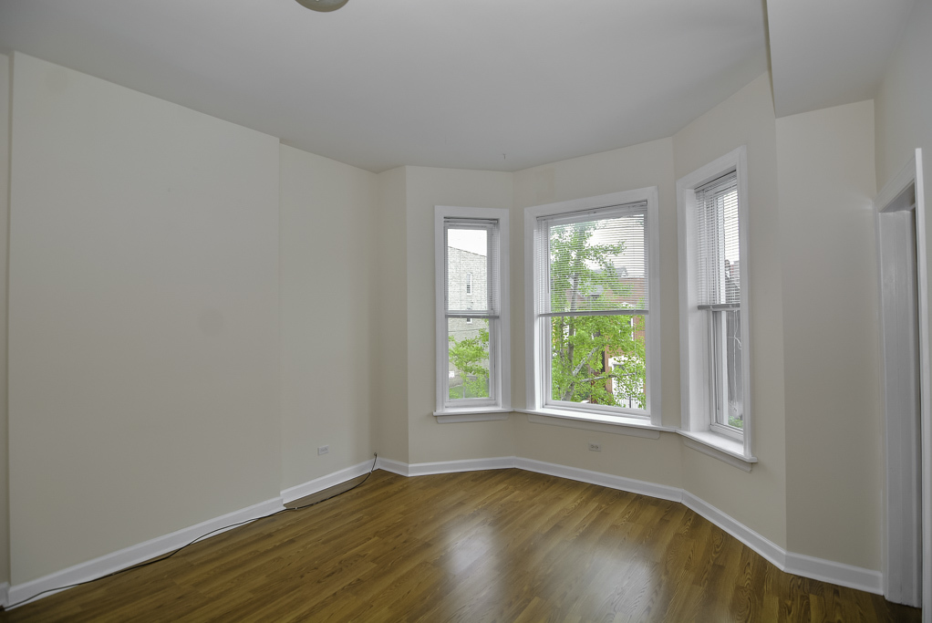 2145 West Chicago Avenue, Unit 2 Chicago, IL 60622 - Photo 7 of 19 a view of an empty room with wooden floor and a window