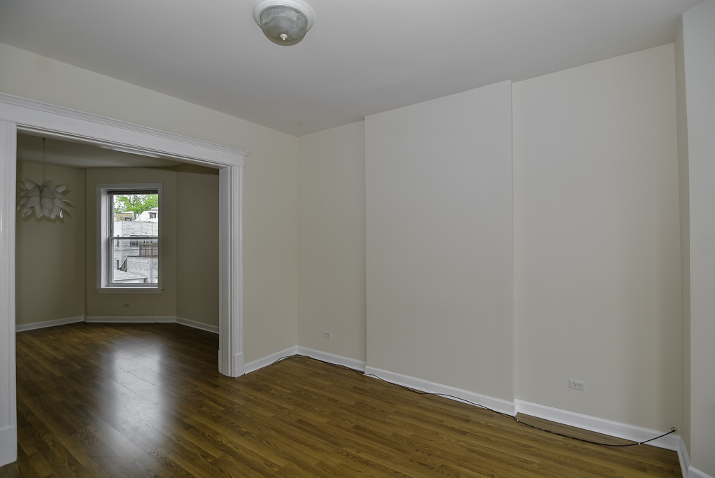 2145 West Chicago Avenue, Unit 2 Chicago, IL 60622 - Photo 8 of 19 a view of an empty room with wooden floor and a window