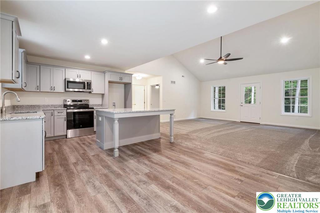 16 Ricks Road New Ringgold, PA 17960 - Photo 6 of 15 a open kitchen with kitchen island a stove a sink dishwasher and a refrigerator with wooden floor