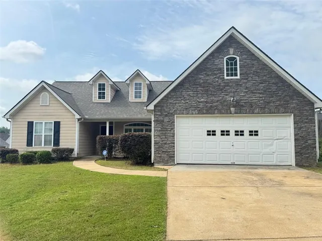 a front view of a house with yard and garage