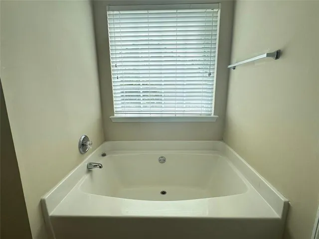 a bath tub sitting in a bathroom next to a window