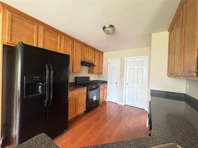 a kitchen with granite countertop stainless steel appliances a refrigerator and cabinets