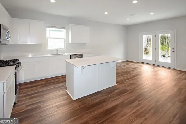 a kitchen with wooden floors and white walls