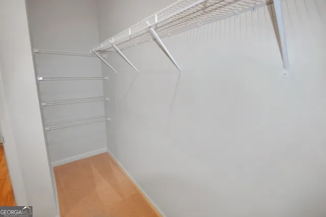 a view of walk in closet with empty racks