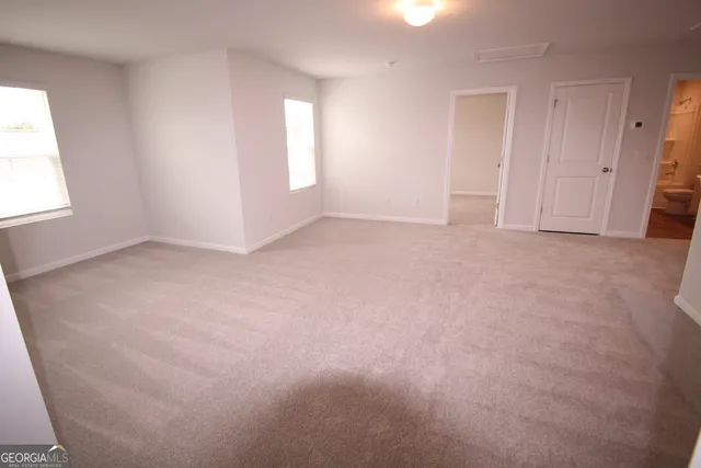 an empty room with windows and closet