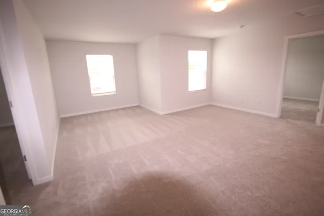 an empty room with windows and closet