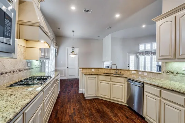 a kitchen with a sink a stove and cabinets