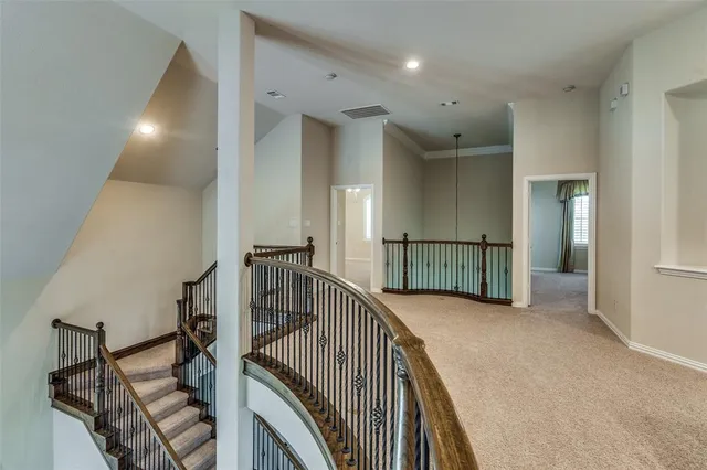 a view of a hallway with wooden floor and stairs