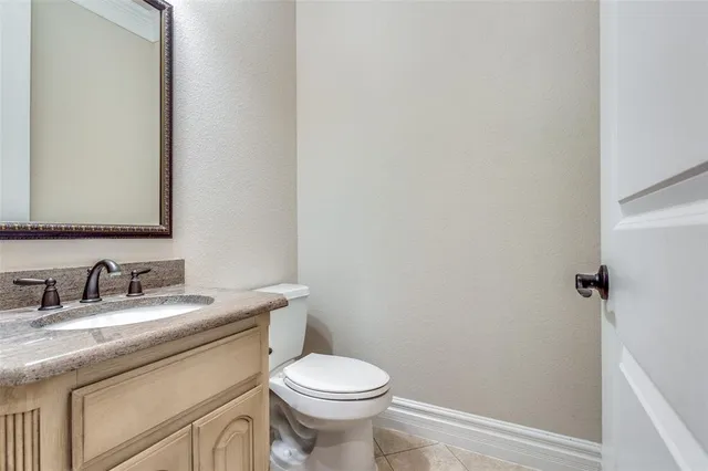 a bathroom with a granite countertop toilet and a sink