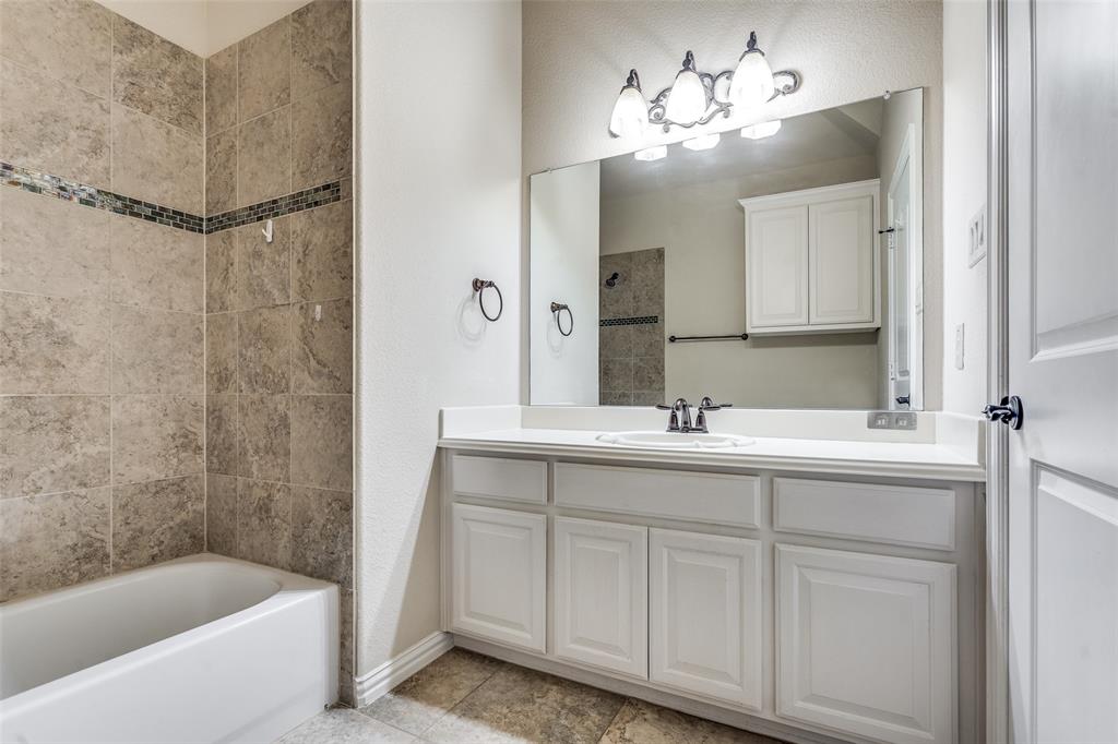 7504 Grace Avenue Plano, TX 75024 - Photo 27 of 36 a bathroom with a sink and a bathtub with a mirror