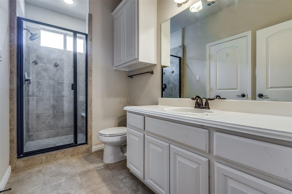 7504 Grace Avenue Plano, TX 75024 - Photo 29 of 36 a bathroom with a double vanity sink toilet and shower