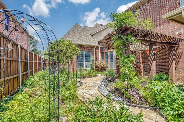 a view of a house with brick walls and flower plants