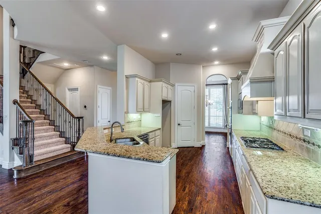 a view of a kitchen with kitchen island granite countertop a large window a sink and a counter top space
