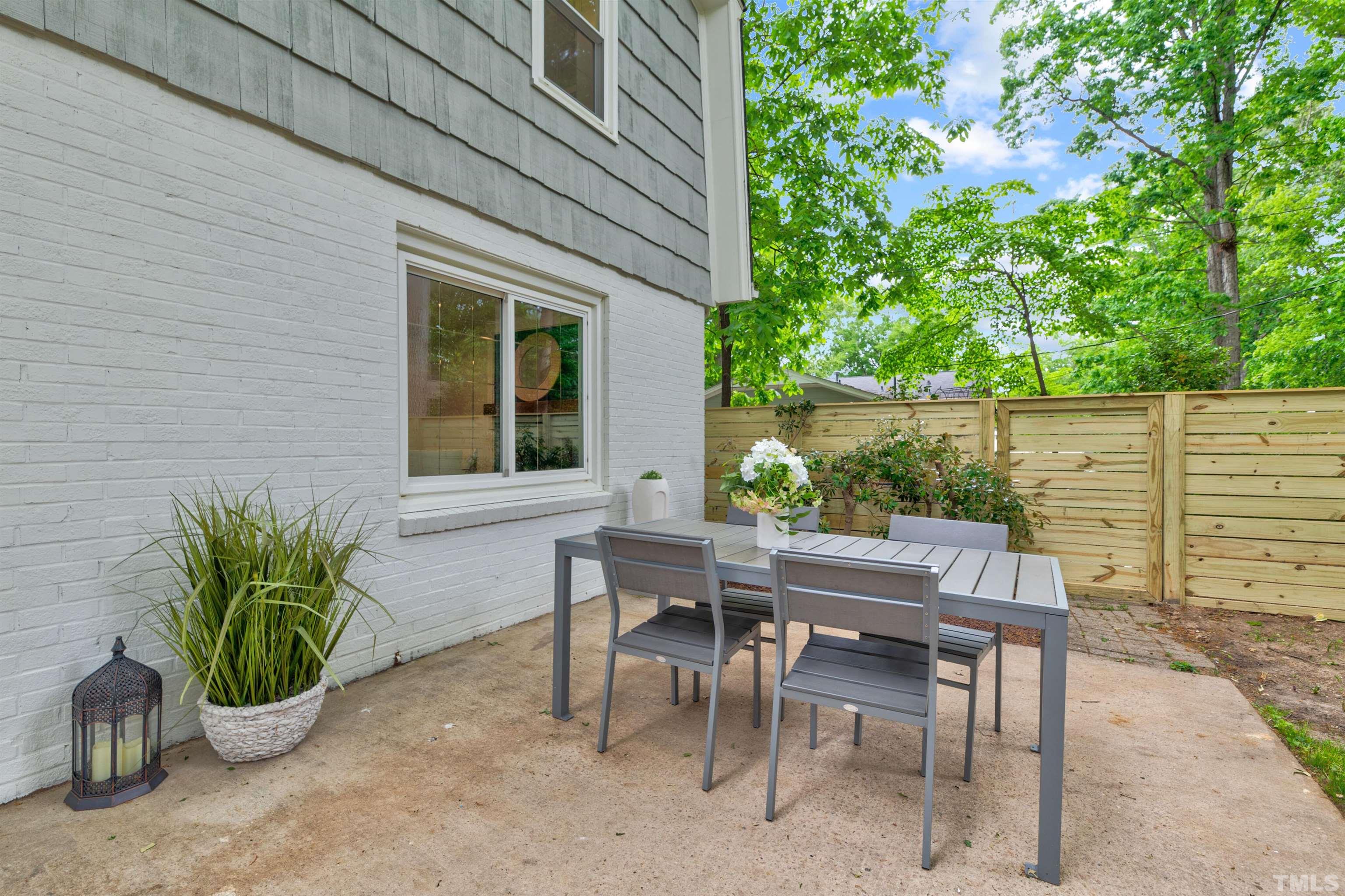 5400 Farley Drive Raleigh, NC 27609 - Photo 29 of 31 a view of a patio with table and chairs potted plants with wooden fence