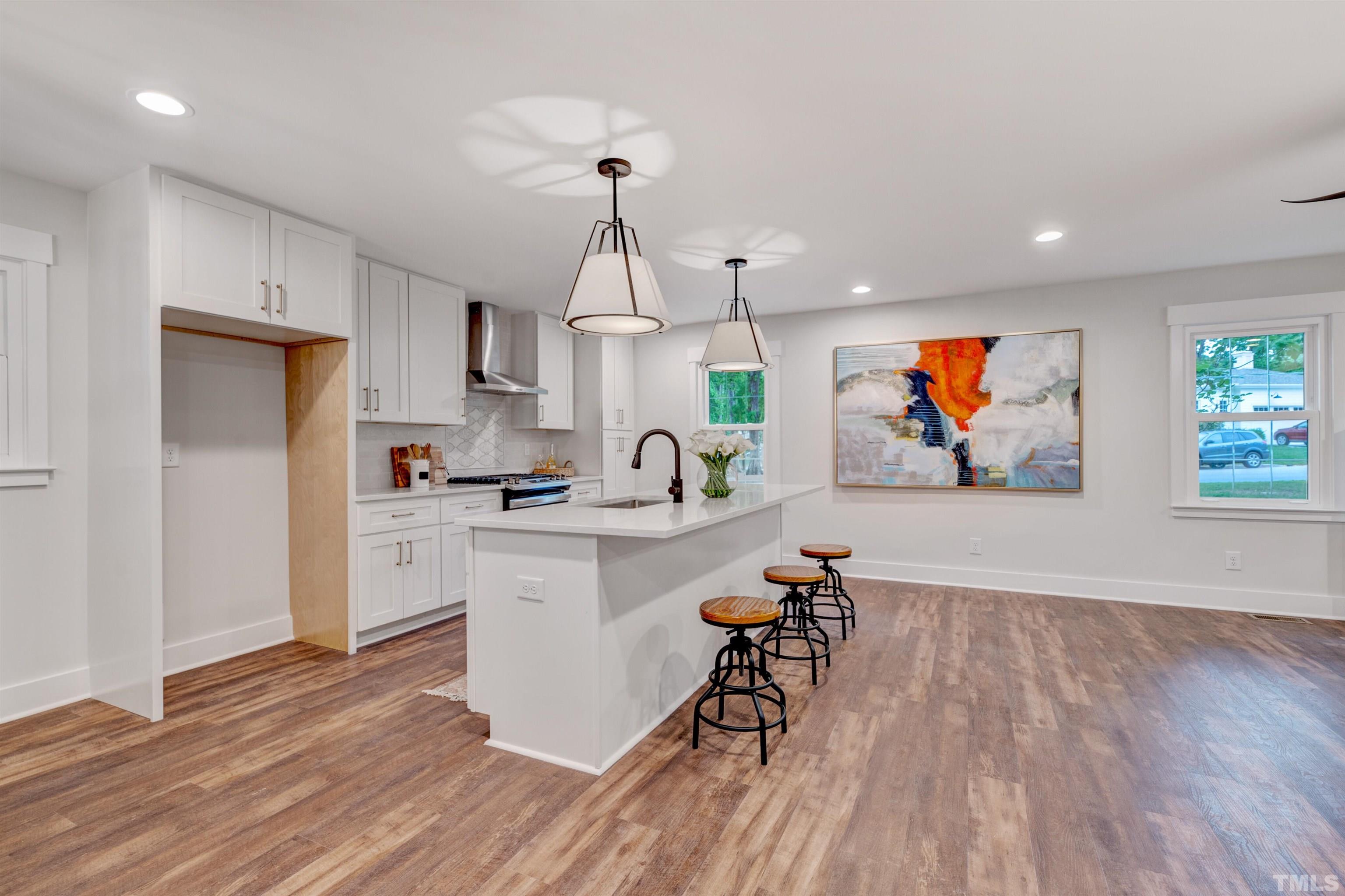 5400 Farley Drive Raleigh, NC 27609 - Photo 6 of 31 a living room with stainless steel appliances furniture and a wooden floor