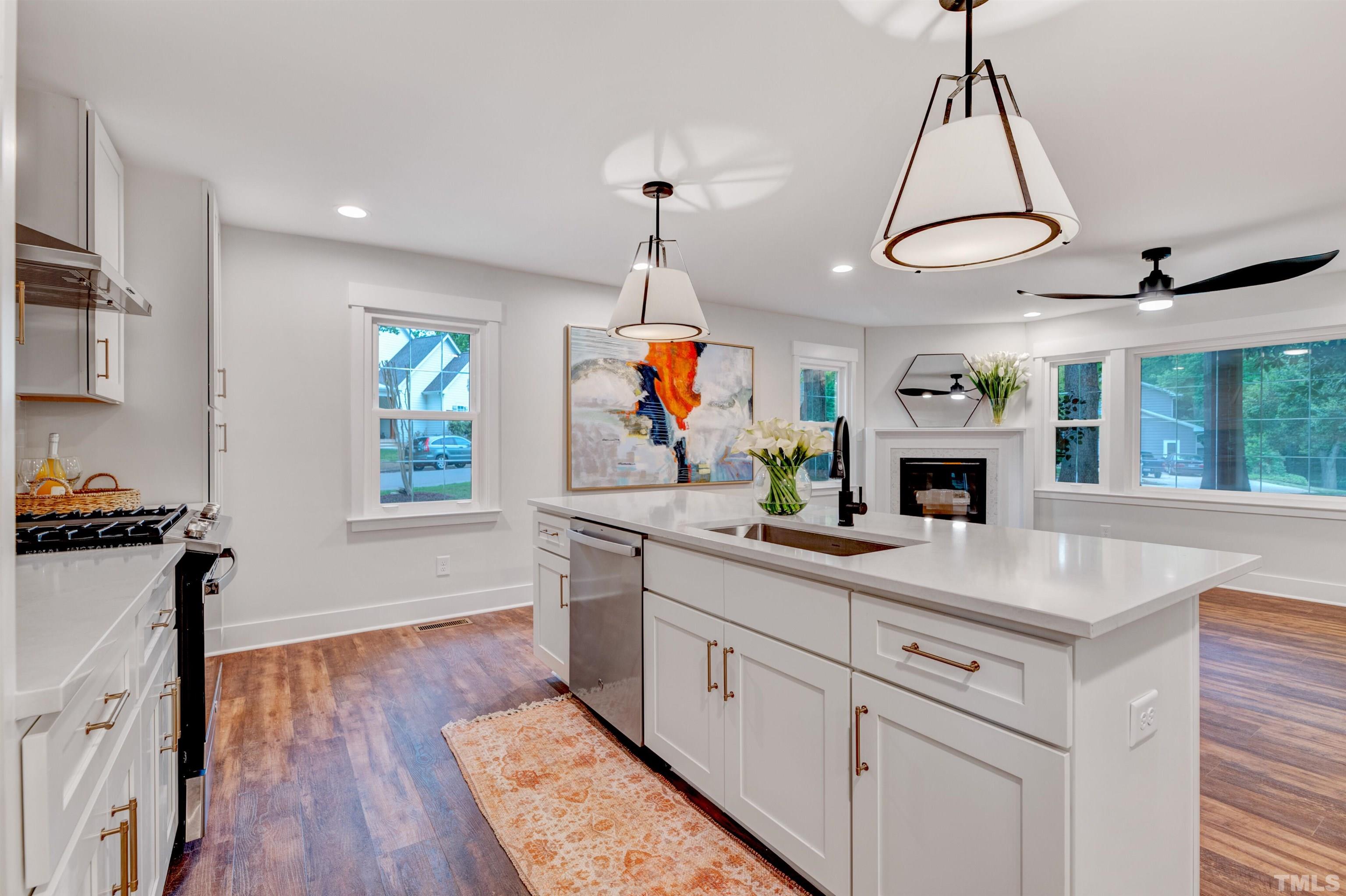 5400 Farley Drive Raleigh, NC 27609 - Photo 7 of 31 a room with kitchen island a sink and a chandelier