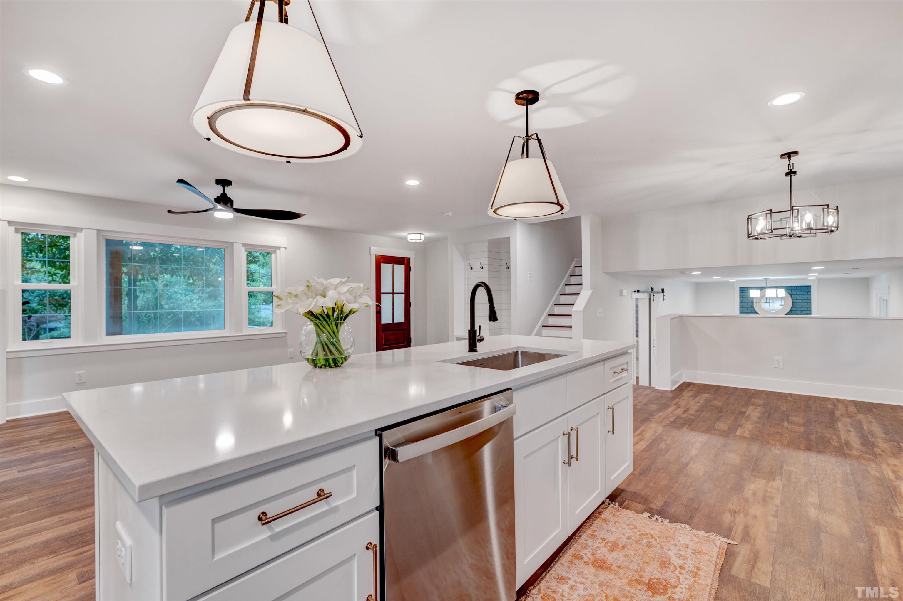 5400 Farley Drive Raleigh, NC 27609 - Photo 10 of 31 a kitchen with stainless steel appliances granite countertop a sink a oven a dining table and chairs with wooden floor
