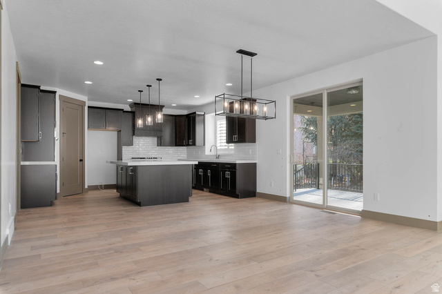 2724 Mt Jordan Road Sandy, UT 84092 - Photo 13 of 33 Kitchen featuring a center island, tasteful backsplash, light wood-style flooring, and hanging lights