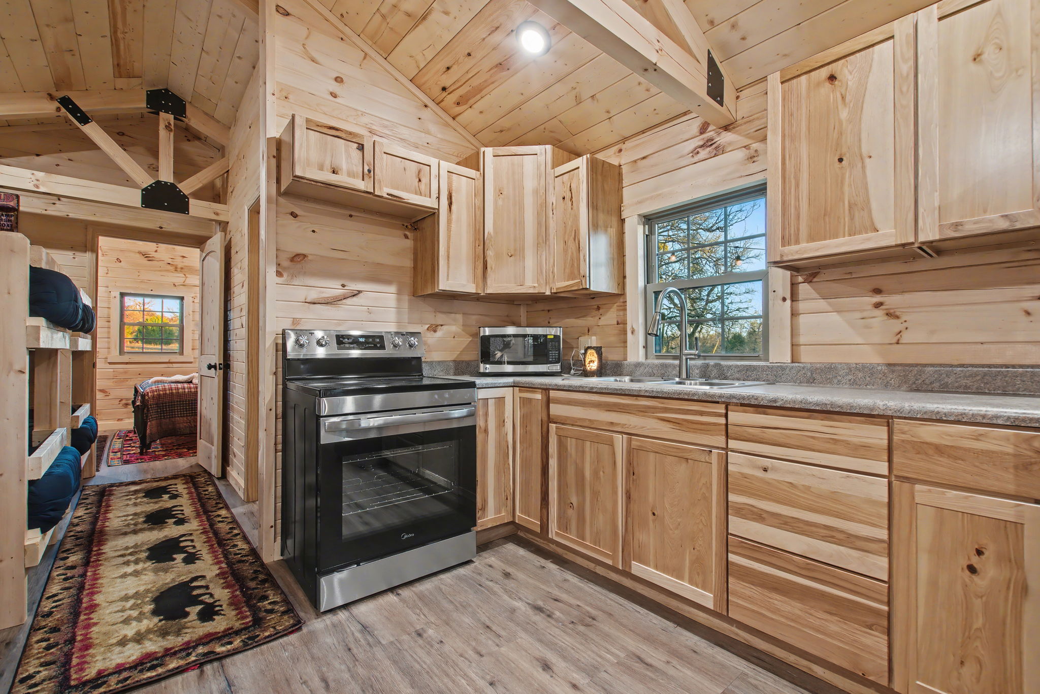 13510 County Road 3642 Kempner, TX 76539 - Photo 25 of 38 Kitchen featuring light brown cabinetry, wooden ceiling, appliances with stainless steel finishes, wood walls, and lofted ceiling