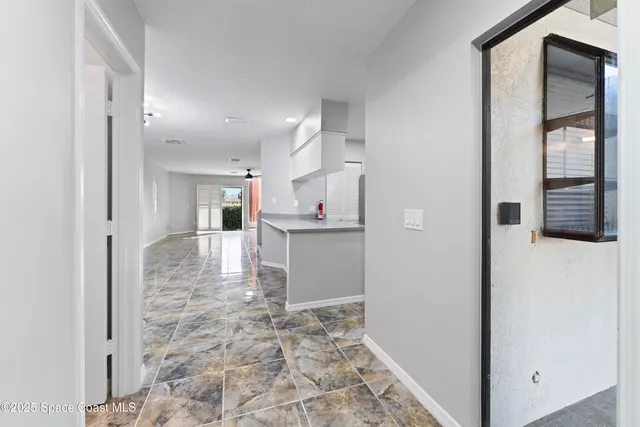 a view of a hallway with wooden floor and cabinet