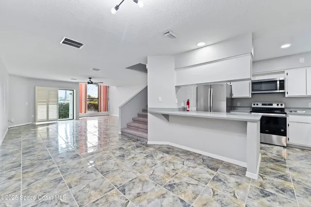 a kitchen with stainless steel appliances granite countertop a refrigerator and a sink