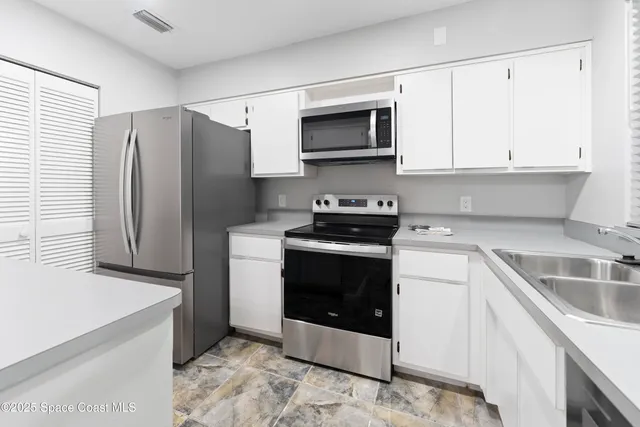 a kitchen with a refrigerator sink and cabinets