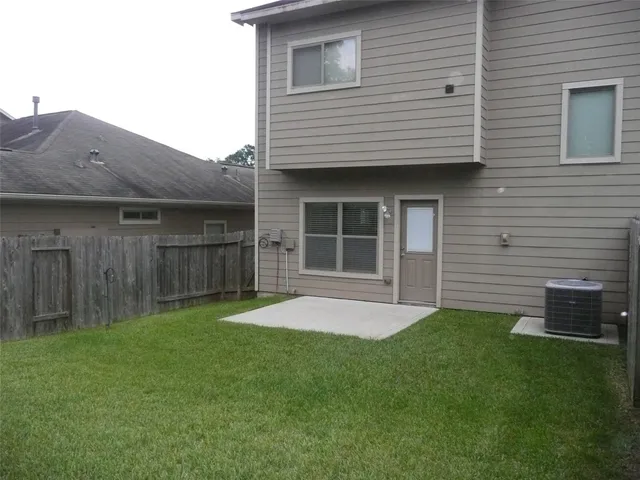 a view of an house with backyard space and wooden fence