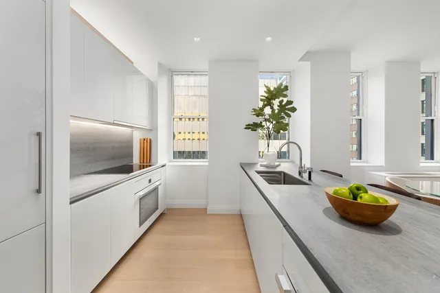 a kitchen with stainless steel appliances a sink a counter top space cabinets and a window