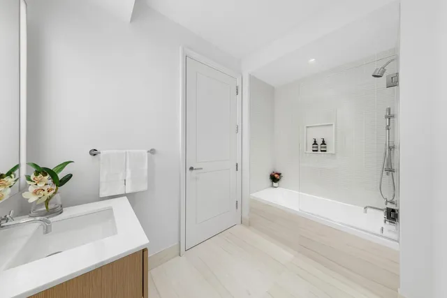 a bathroom with a bathtub sink and mirror