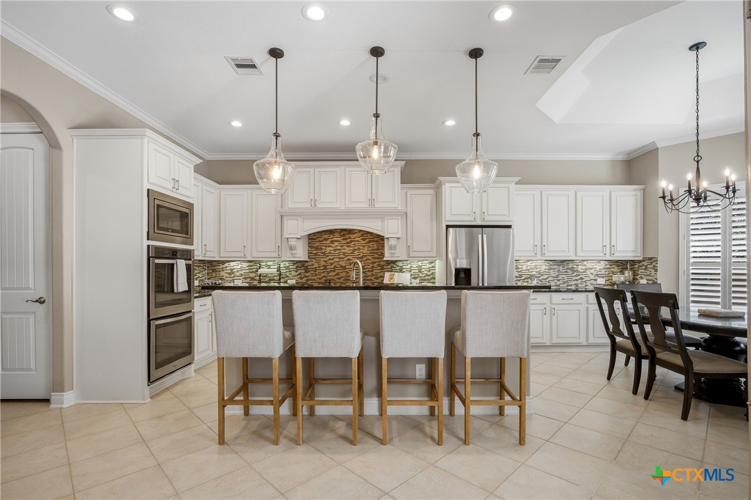 2427 Anderson Point Lane Spring, TX 77388 - Photo 22 of 47 a kitchen with stainless steel appliances kitchen island granite countertop a table and chairs in it