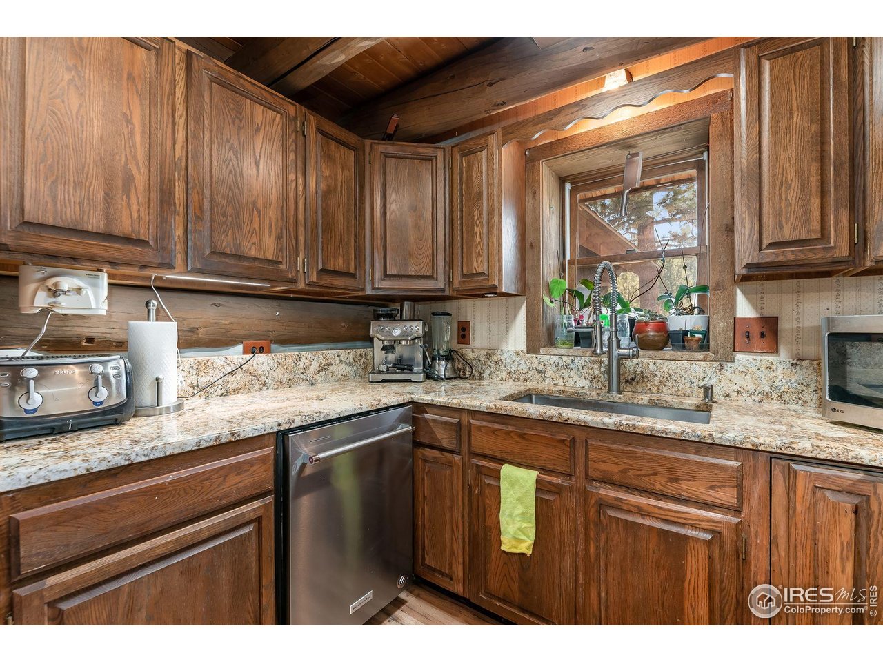 212 Valley Road Lyons, CO 80540 - Photo 6 of 38 a kitchen with granite countertop stainless steel appliances a sink window and cabinets