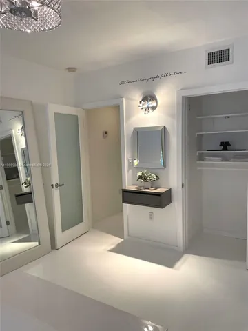 a bathroom with a granite countertop sink a mirror and a bathtub