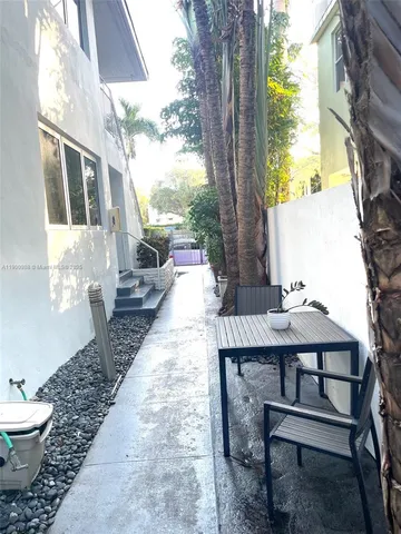a view of a patio with table and chairs under an umbrella