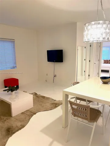 a living room with a bed furniture and a flat screen tv