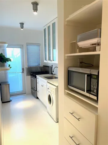a kitchen with granite countertop white cabinets and white appliances