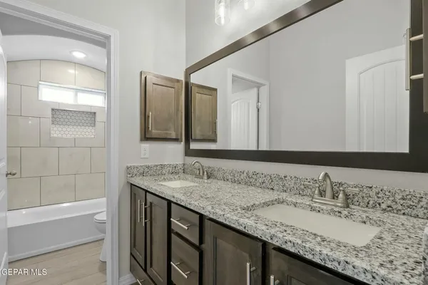a bathroom with a granite countertop sink and a mirror