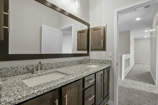 a bathroom with a granite countertop sink and a mirror